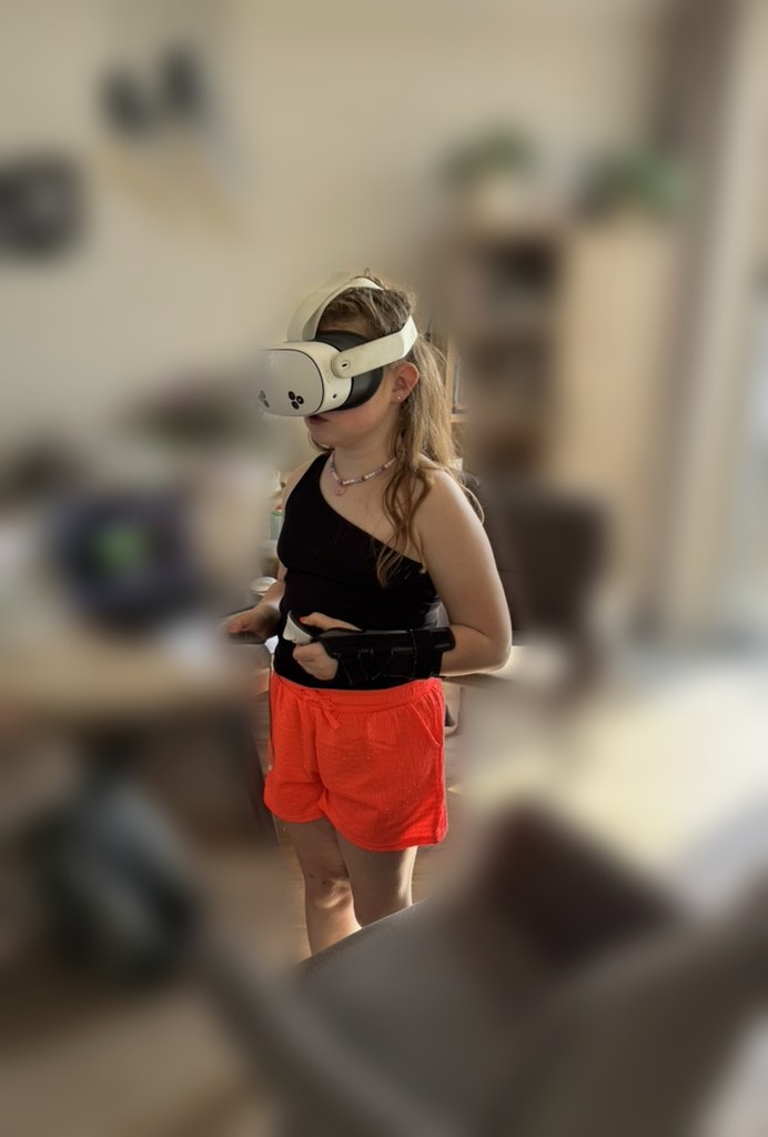 Meisje met VR-bril en controller staat middenin de kamer, volledig opgegaan in haar eigen tekenwereld